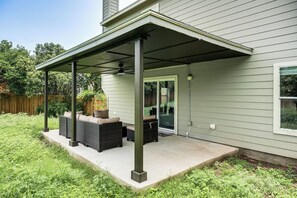 A covered patio with outdoor furniture, a ceiling fan, and a door leading to a garage. - Pool Table & Patio! Group Hub, 4 Mi to SeaWorld (San Antonio)