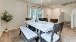 A dining area with a large table, benches, chairs, a potted plant, and a staircase. - Pool Table & Patio! Group Hub, 4 Mi to SeaWorld (San Antonio)