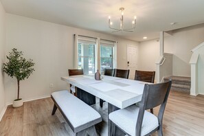 A dining area with a large table, benches, chairs, a potted plant, and a staircase. - Pool Table & Patio! Group Hub, 4 Mi to SeaWorld (San Antonio)