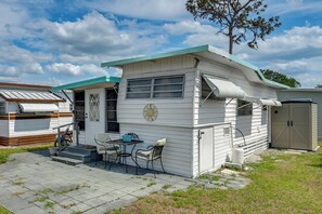 A mobile home with a patio, a table, chairs, and a bicycle. - Heated Pool, Games & Socials! Zephyrhills Home (Zephyrhills)