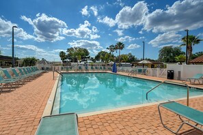 A swimming pool with lounge chairs, palm trees, and a clear sky. - Heated Pool, Games & Socials! Zephyrhills Home (Zephyrhills)