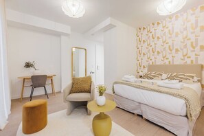 Quarto moderno com cama, escrivaninha, cadeira e mesa redonda.