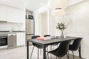 A modern kitchen with white cabinetry, a built-in oven, and a microwave. - Edmond Vibes Madrid Río (Madrid)
