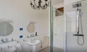 Une salle de bain avec une douche, un lavabo et un miroir.