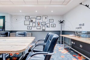 A conference room with a long table, chairs, a clock, framed pictures on the wall, and a coat rack. - Manchester Portland By Sunday - Standard Single Room (Manchester)