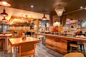 A restaurant interior with wooden tables, bar area, and hanging pendant lights. - Manchester Portland By Sunday - Compact Double Room (Manchester)