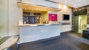 A reception desk with a digital screen, a TV, and a sign for OYO. - Brentwood Aberdeen City Centre - Standard Twin Room (Aberdeen)