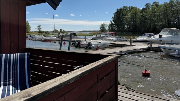 Un muelle con barcos, una estructura de madera y vistas al agua.