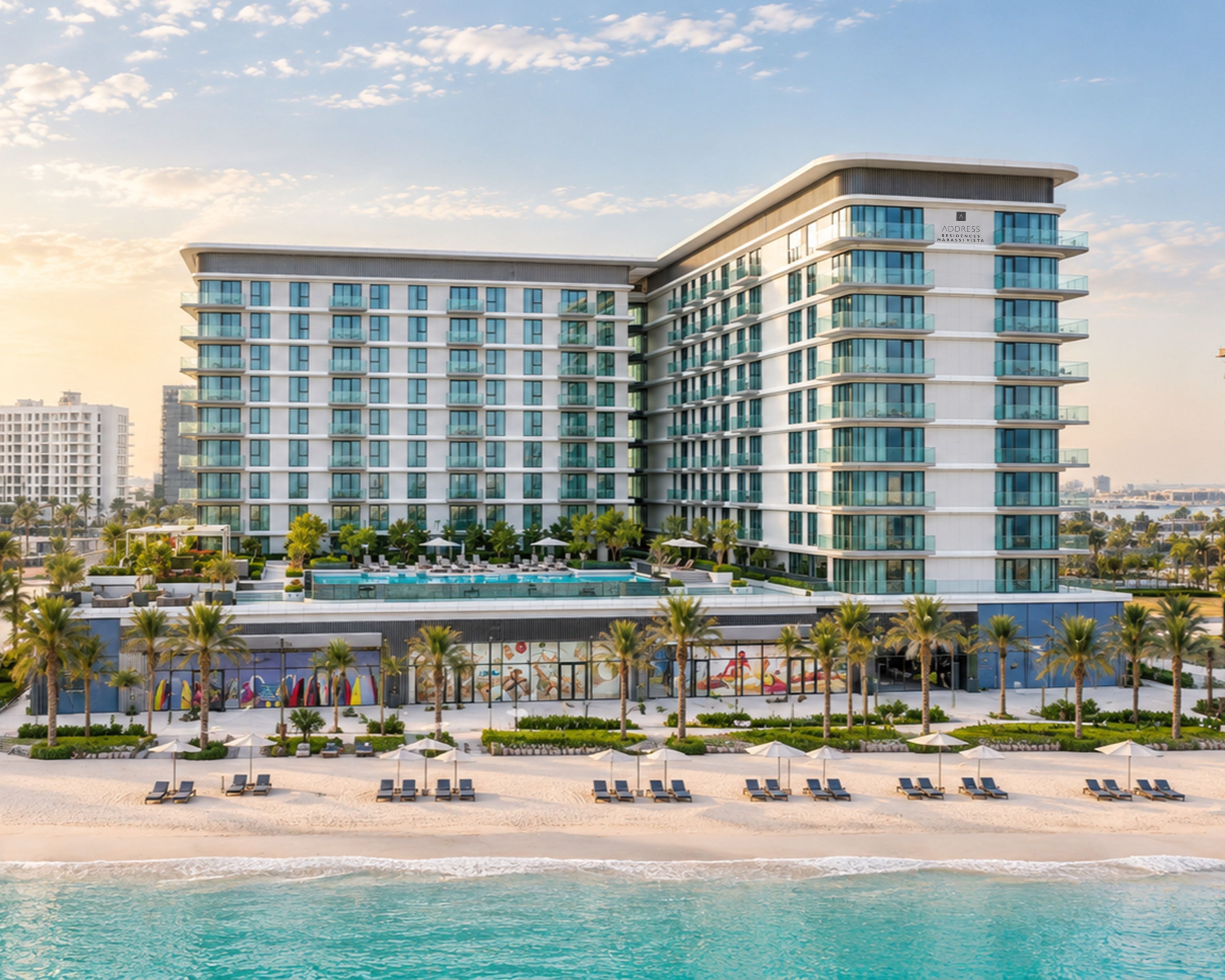 Ein modernes Hotel mit Pool, Strandliegen und Meerblick.