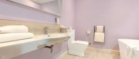A bathroom with a sink, toilet, and bathtub.