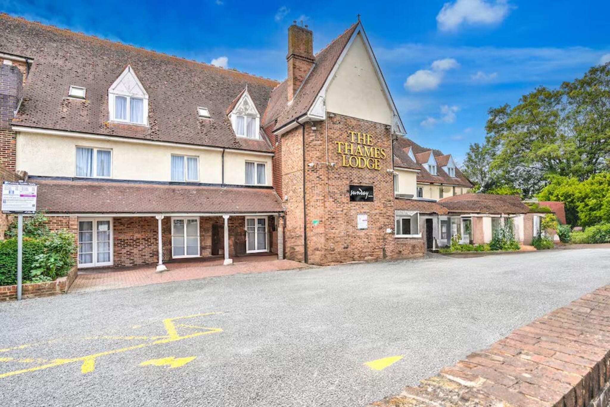 A traditional brick building with a sign reading 'The Thames Lodge.'
