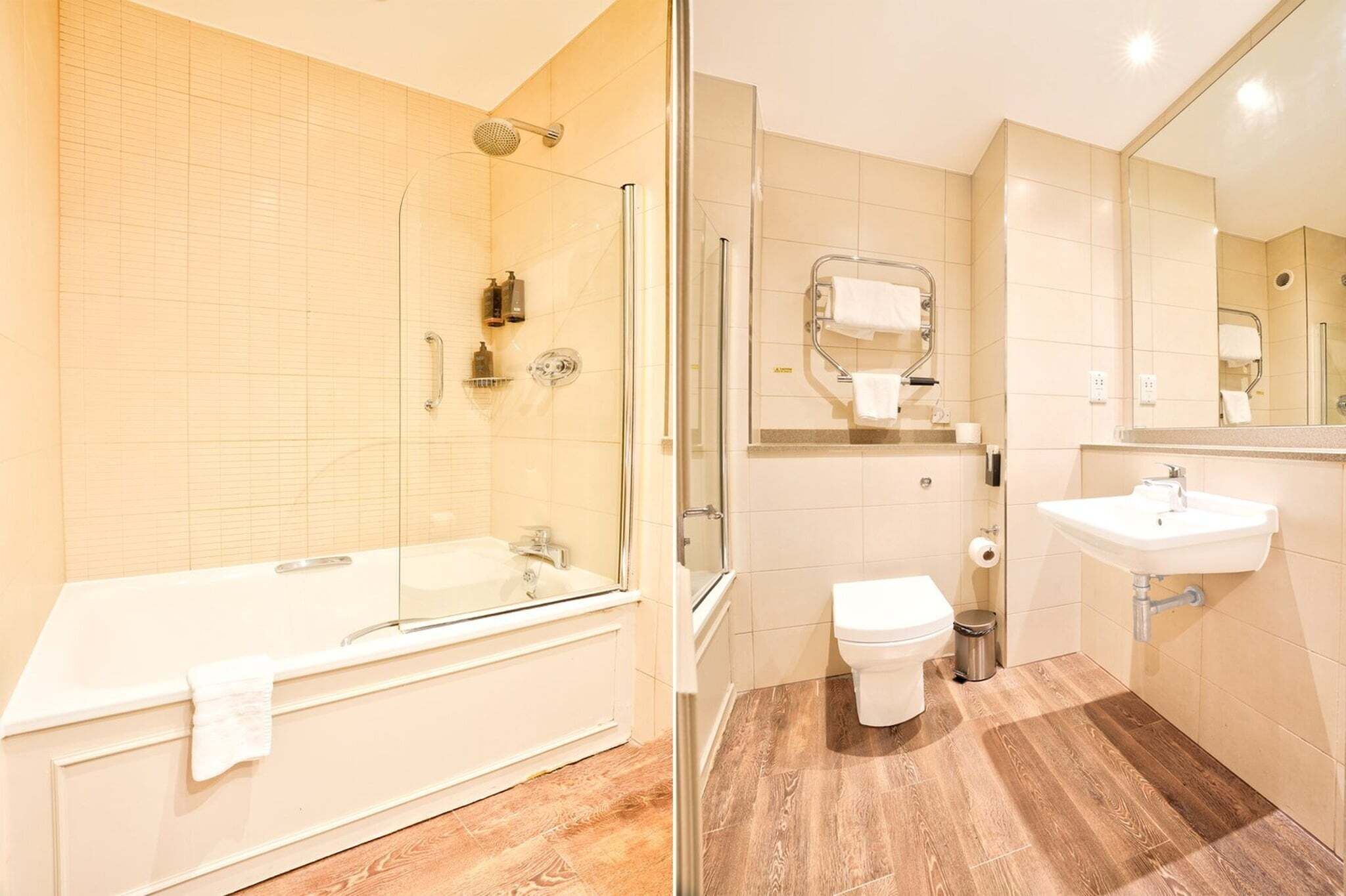 A bathroom with a glass-enclosed shower, a bathtub, a toilet, and a sink.