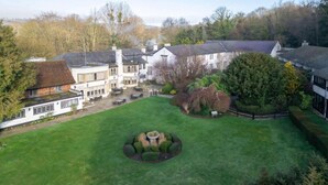 A large estate with multiple buildings, a well-maintained lawn, and a circular garden feature. - Sunday Box Hill Burford Bridge - Classic Double room (London)