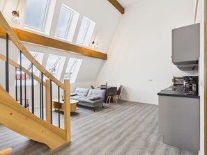 A loft-style apartment with a staircase, a dining area, and a kitchenette. - Spacious maisonette apartment for families and groups of up to 8 people (Görlitz)