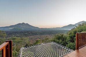 Eine Hängematte auf einer Holzterrasse mit Blick auf eine Berglandschaft.