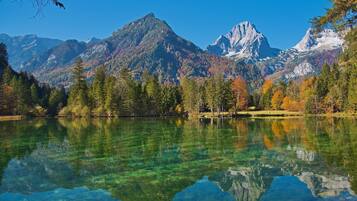 A clear lake reflecting mountains and trees.