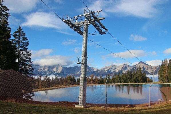A utility pole with a power line, a fenced area, and a mountain backdrop.