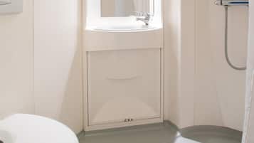 A bathroom with a white sink, a mirror, and a shower.