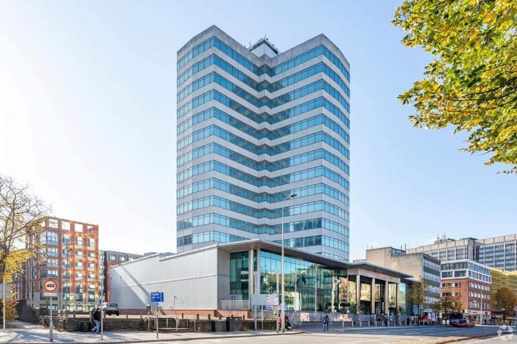 Un edifici modern amb façana corbada, grans finestres i teulada plana.