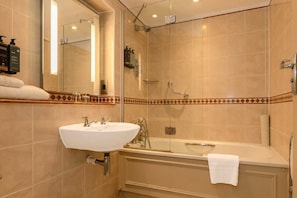 A bathroom with a sink, mirror, shower, and bathtub.