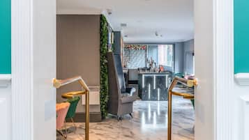 A modern interior with a staircase, a bar area, and seating.