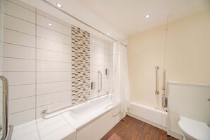 Un baño moderno con bañera, ducha e inodoro.