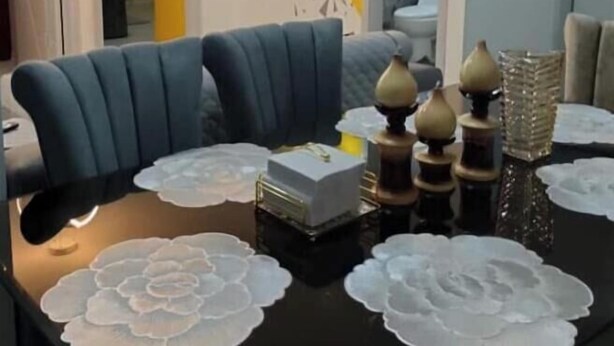 A modern living room with a dark wooden coffee table, blue sofa, decorative vases, and a wall with geometric patterns. - Modern Comfort and Convenience in South Quito (Pichincha)