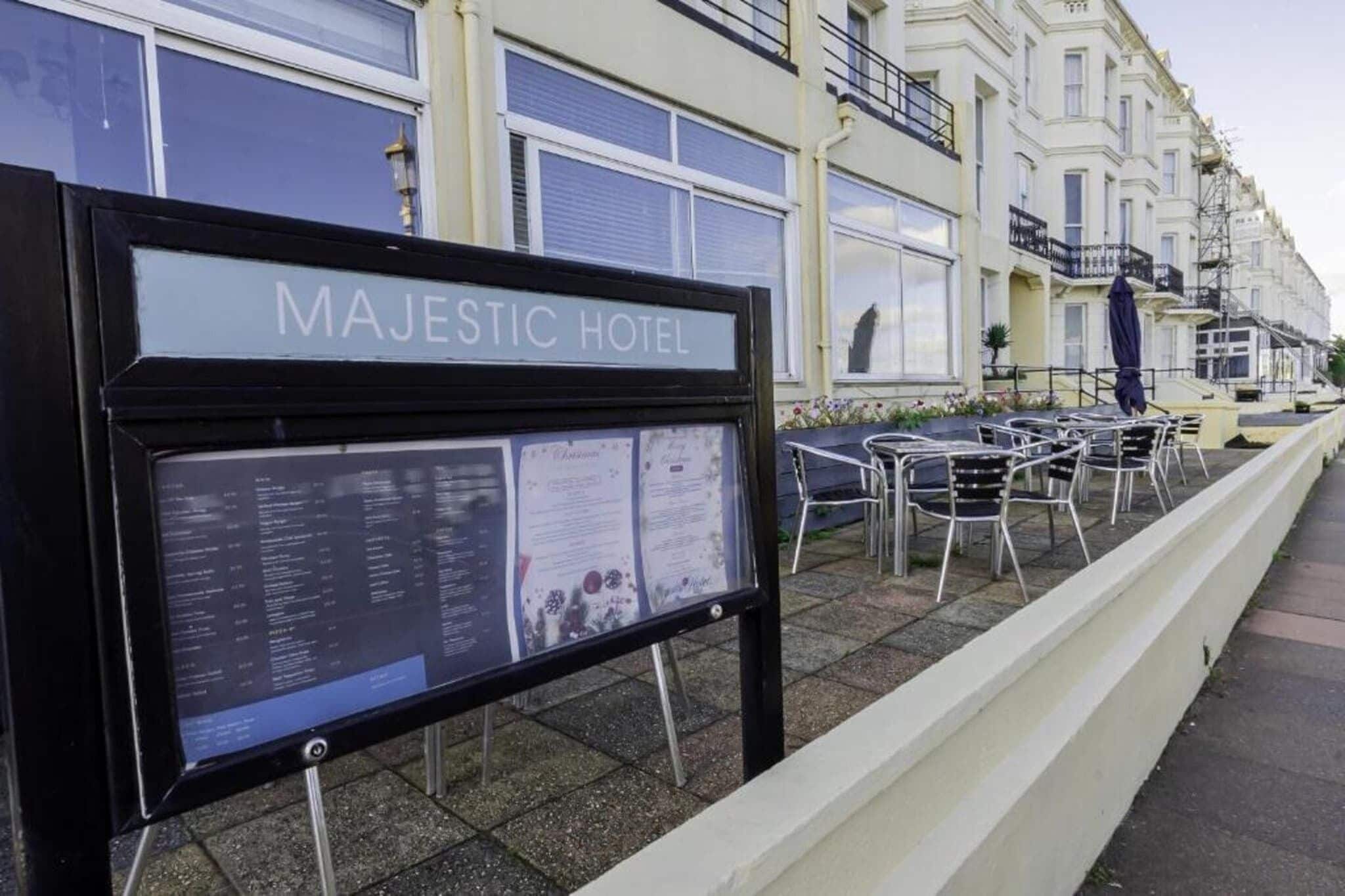 Ein Schild des Majestic Hotels mit einer Auflistung der Zimmerarten und Annehmlichkeiten.