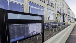 Un cartel para el Hotel Majestic con una lista de tipos de habitaciones y servicios.