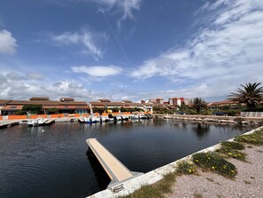 A marina with boats docked, a dock, and residential buildings in the background.