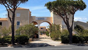 A residential area with a sign reading 'RESIDENCE HACIENDAS,' a paved road, and trees. - Family apartment with large terrace, swimming pool, parking and wifi fiber (Le Barcarès)