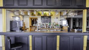 A bar area with a coffee menu, bar stools, and a variety of bottles and glasses.