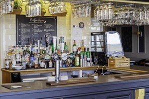 A bar area with a coffee menu, various liquor bottles, and a beer tap. - Double room with sea view (Eastbourne)