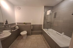 Un bany amb rentamànega, vàter, banyera i dutxera.