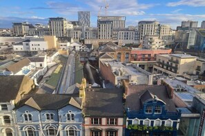 Eine Stadtansicht mit einer Mischung aus modernen und älteren Gebäuden, darunter ein markantes Gebäude mit einem Uhrturm.