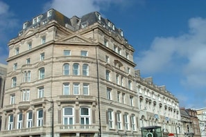 A multi-story building with classical architecture, featuring arched windows and decorative moldings. - Standard Double Room - No Window (Cardiff)