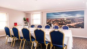 A conference room with a cityscape view, a large window, and a table set for a meeting. - Royal Hotel Cardiff by Belvilla - Standard Double Room - No Window (Cardiff)