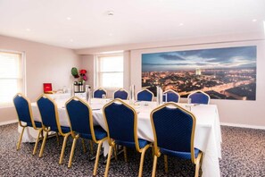 A conference room with a cityscape view, a large window, and a table set for a meeting. - Royal Hotel Cardiff by Belvilla - Standard Double Room - No Window (Cardiff)