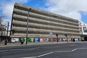 A multi-story building with a flat facade, a street in front, and a traffic light. - Superior Double Room (Cardiff)