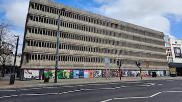 A multi-story building with a flat facade, a street in front, and a traffic light.