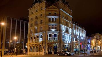 A multi-story building with illuminated windows and a corner entrance.