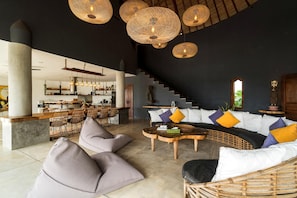 A modern interior with a dining area, a sofa set, and a staircase. - Villa Magena (Badung)