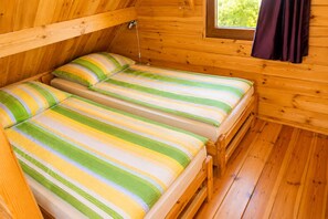 A wooden cabin with two bunk beds, a window with curtains, and a wooden floor. - Cottages for 5 People With a Swimming Pool (Kamien Pomorski)