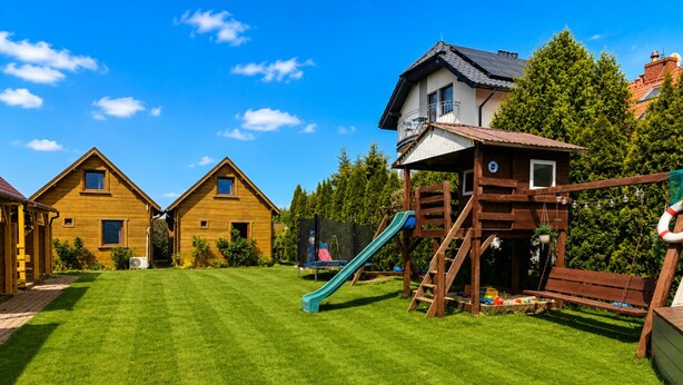 A residential area with wooden houses, a playground, and a well-maintained lawn. - Cottages for 5 People With a Swimming Pool (Kamien Pomorski)