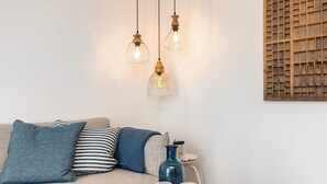 A cozy living area with a round coffee table, a blue vase, and two candles.