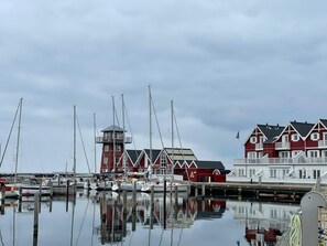 A marina with boats, a lighthouse, and red buildings. - 4 Star Holiday Home in Bagenkop (Sydlangeland)