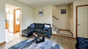 A living room with a sectional sofa, a coffee table, a rug, and a staircase leading to another level. - Great for Families! Richmond Townhome w/ Patio (Richmond)