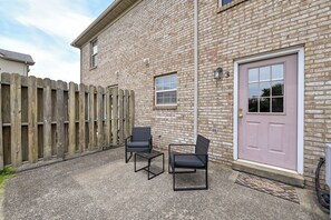 A brick building with a wooden fence, a door, and two chairs. - Great for Families! Richmond Townhome w/ Patio (Richmond)