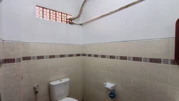 Un baño pequeño con inodoro, ventana y ducha.