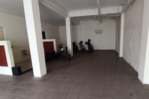 A hallway with tiled flooring, white walls, and a sign indicating a hazardous area.